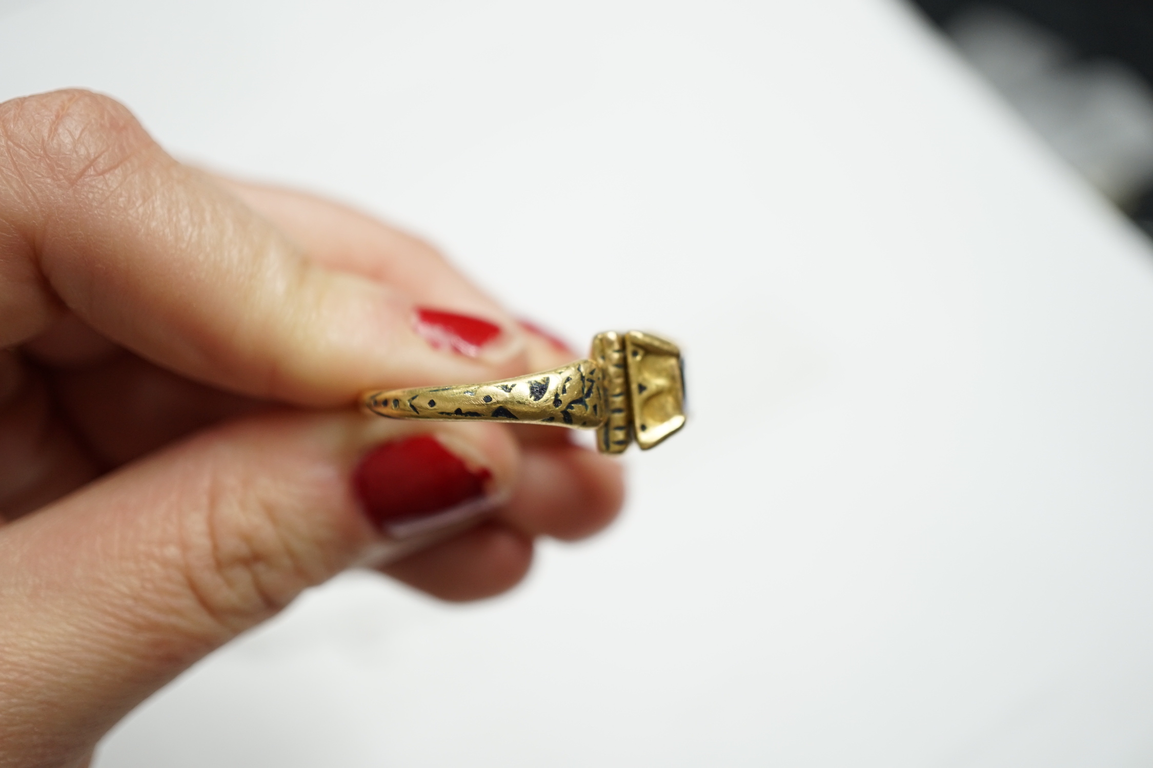 An antique high carat gold, black enamel and collet set cushion cut sapphire set 'poison' ring